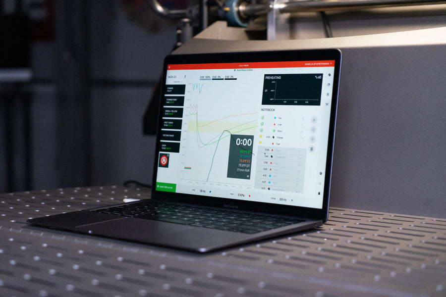 A Macbook Air with RoastPATH® software open sits on the cooling tray of a 20 kilogram Mill City Roaster® 