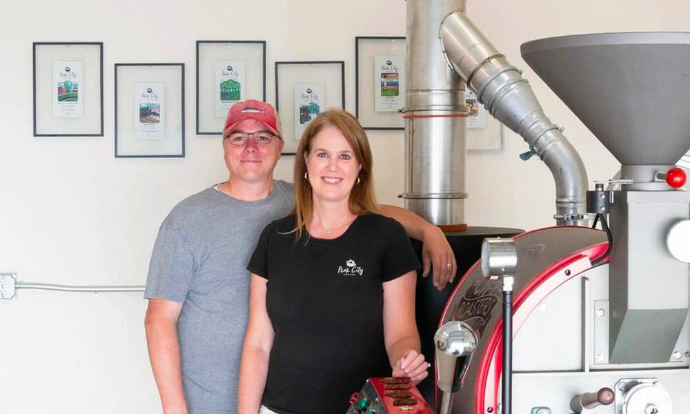 Couple stands next to 10 kilogram Mill City Roaster