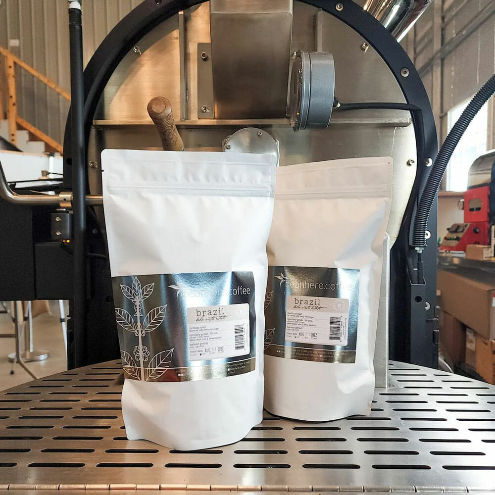 Two coffee bags sitting on top of the roaster cooling tray.